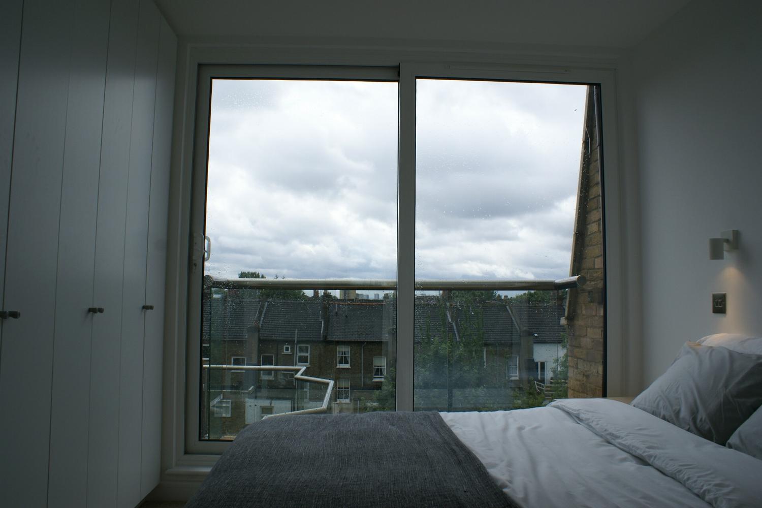 a bedroom with a bed and a large window