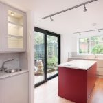 Elegant bespoke kitchen design with a door open to garden