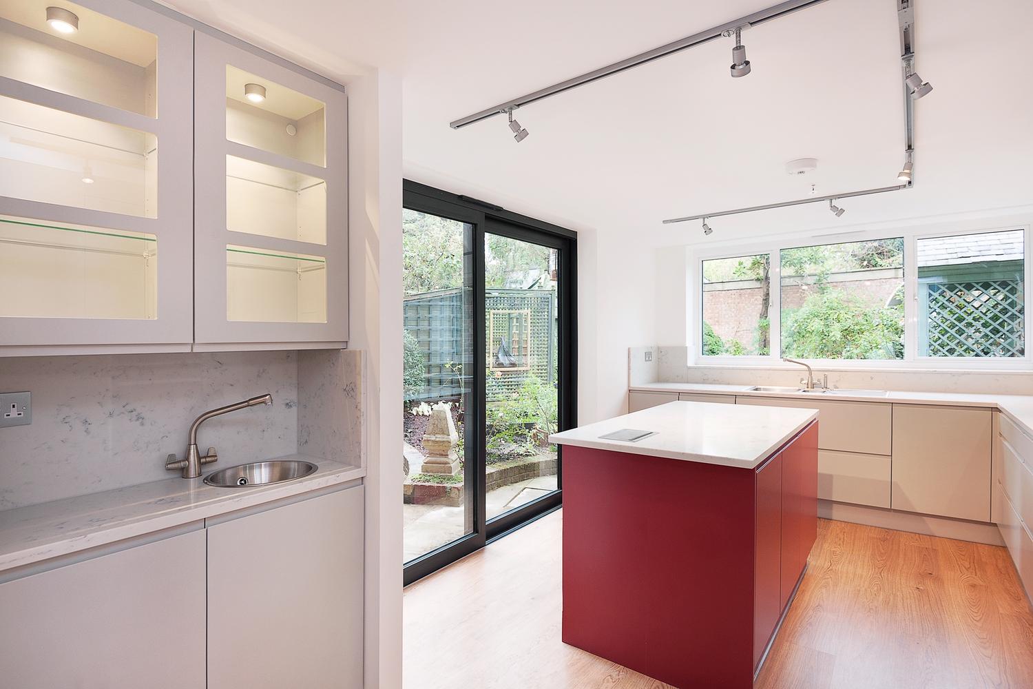 Elegant bespoke kitchen design with a door open to garden