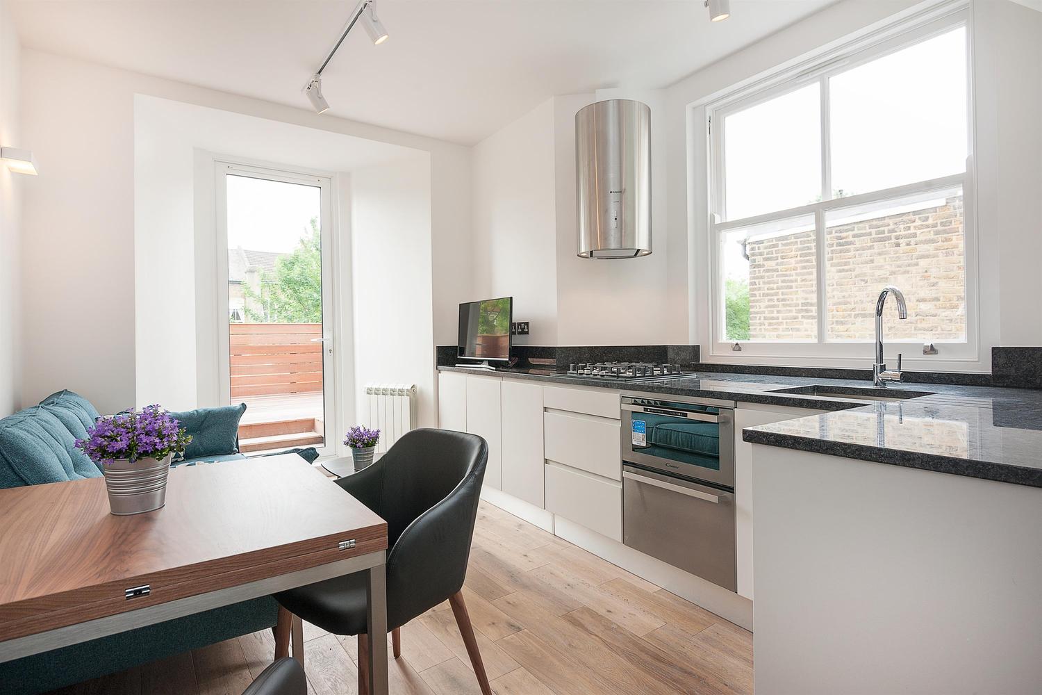 Closed kitchen design with a small dining table and couch