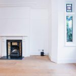 a room with a fireplace and a large window