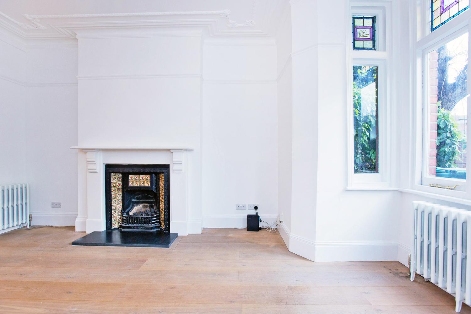 a room with a fireplace and a large window